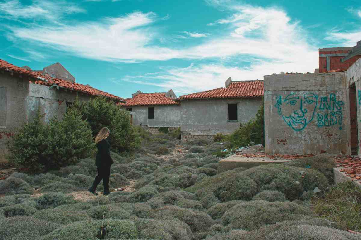 donna che passeggia per un borgo abbandonato