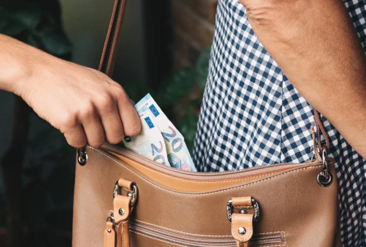 Mano che prende due banconote da 20 euro da una borsa